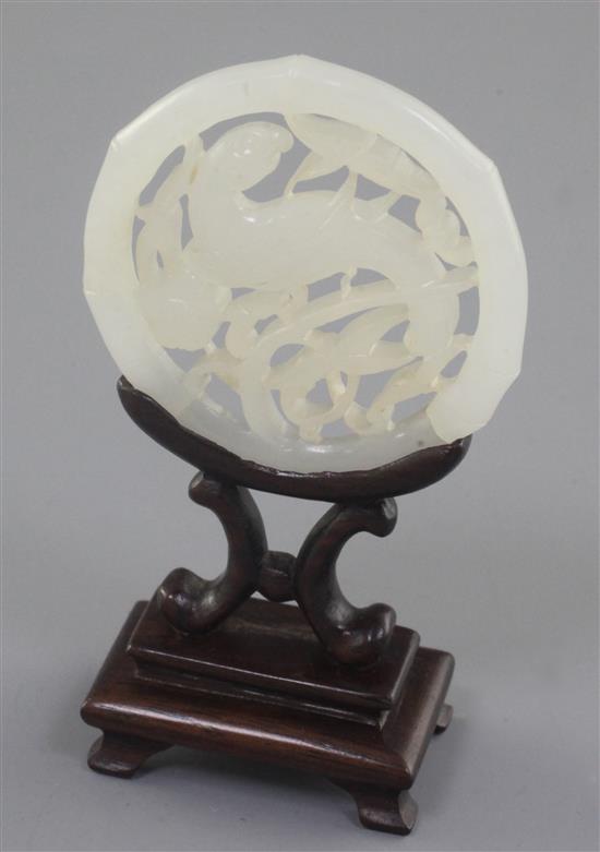 A Chinese white jade parrot disc, 19th century, 5.2cm, wood stand